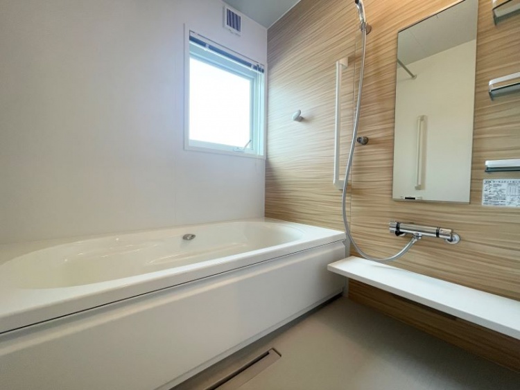 明るい木目調パネルが印象的なバスルーム。窓からの自然光が差し込み、清潔感あふれる空間に。広々とした浴槽と使いやすいシャワー設備で、毎日のバスタイムを快適に過ごせます。