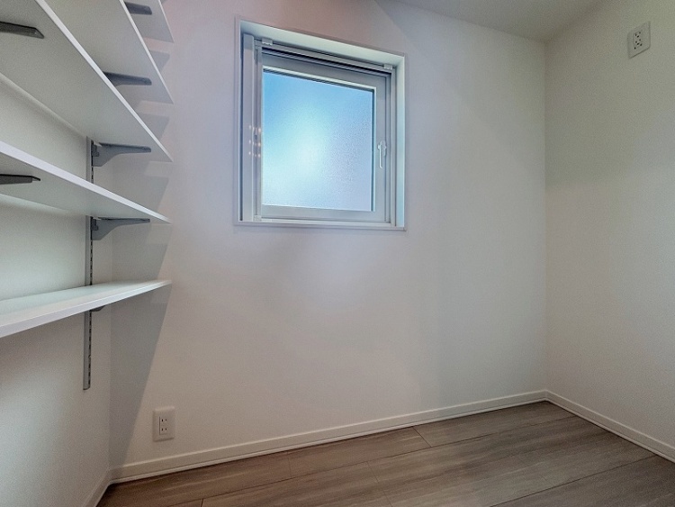 小さな窓から光が入る明るい空間に、片側の壁には白い棚が並んでいます。