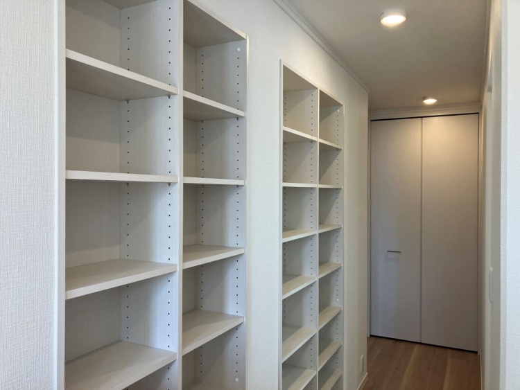 明るく機能的な収納スペース。壁一面には可動式の棚が並び、本や小物、日用品の整理に最適です。