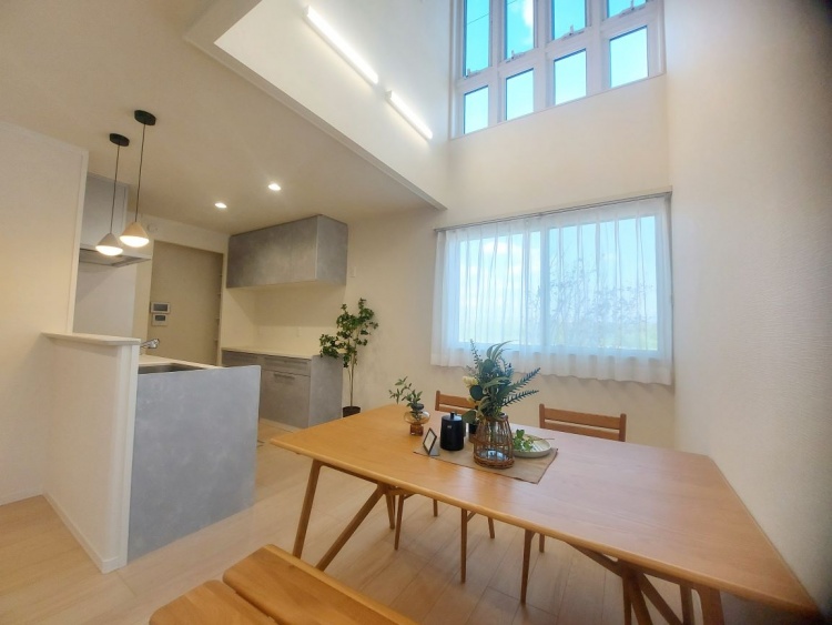 吹き抜けの天井から光が降り注ぎ、窓辺の花瓶に生けられた草花がやさしく輝いています。