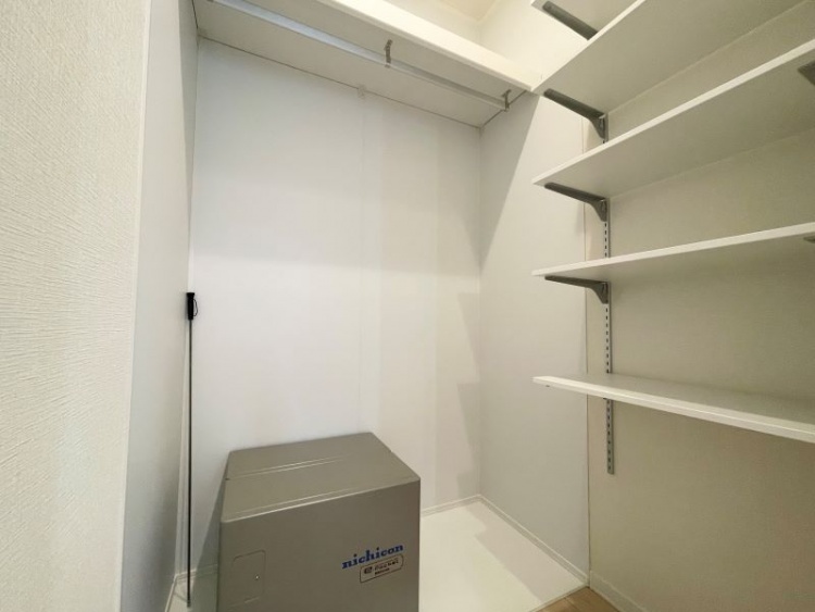 可動式の棚とハンガーパイプが設置された収納スペース。蓄電池も設置されており、機能性と収納力を兼ね備えたユーティリティ空間です。