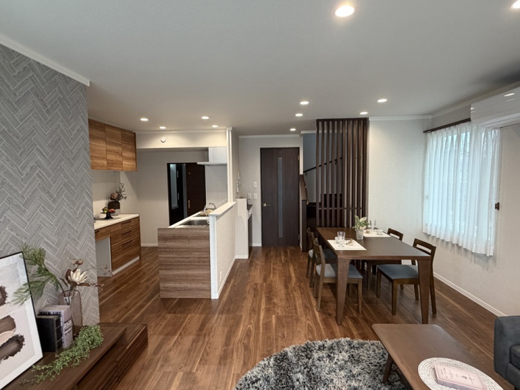 木目調を基調としたキッチン。奥には洗面脱衣室への引き戸があり、右側にはダイニングが見えます。