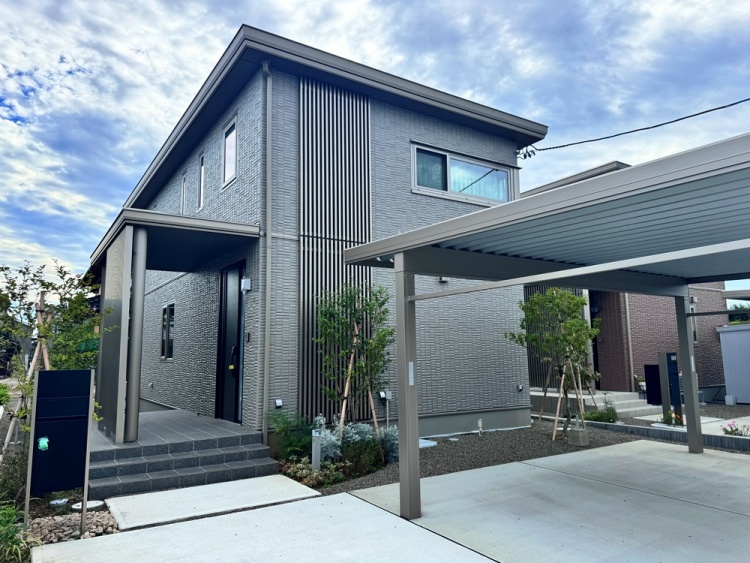 グレーの外壁の２階建て住宅のA棟外観。玄関前にカーポートがあります。