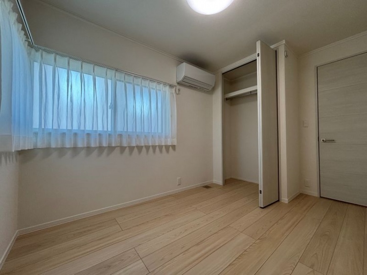 白を基調とした寝室。収納、窓が設置されています。