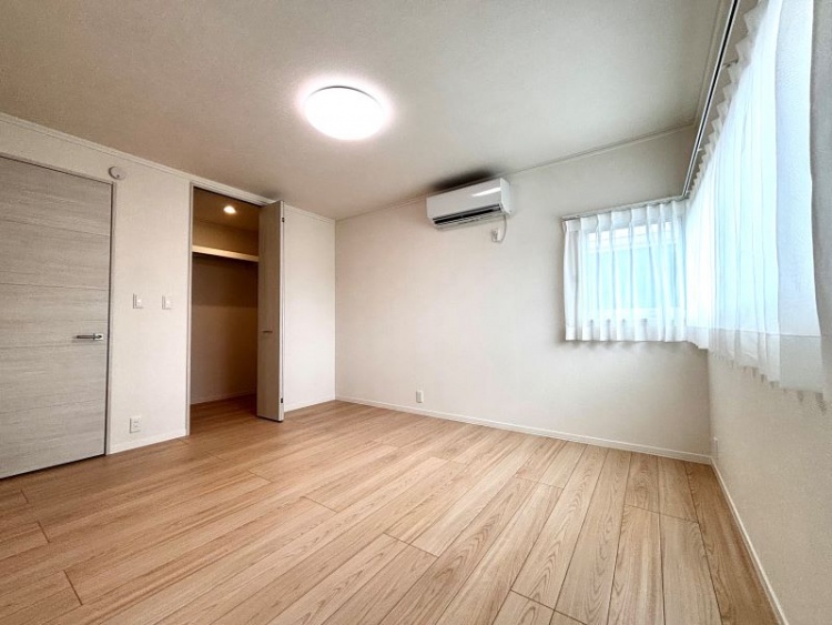 白を基調とした主寝室。エアコン、L字型の窓、ウォークインクローゼットが設置されています。