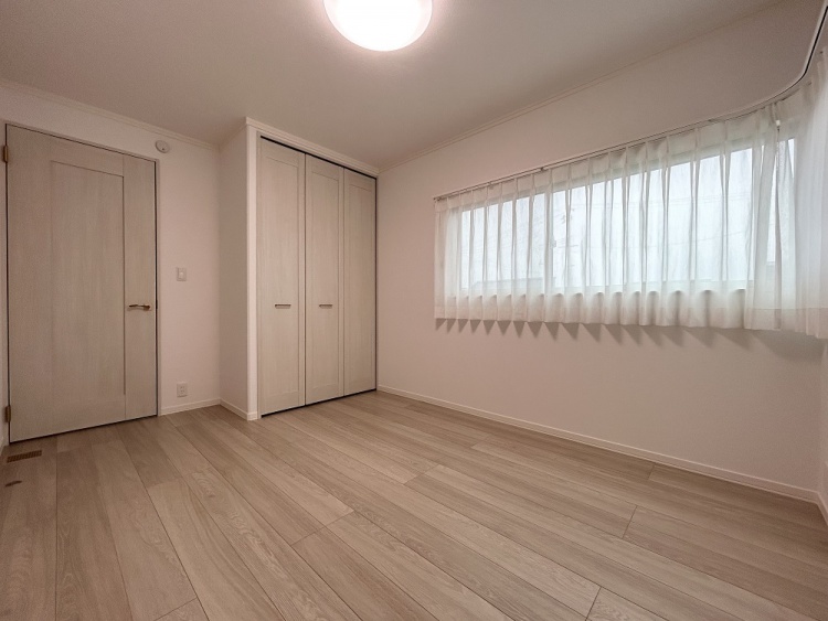 白を基調とした壁と建具、やわらかな光を通すカーテンが調和し、穏やかであたたかみのある空気に包まれた居室です。