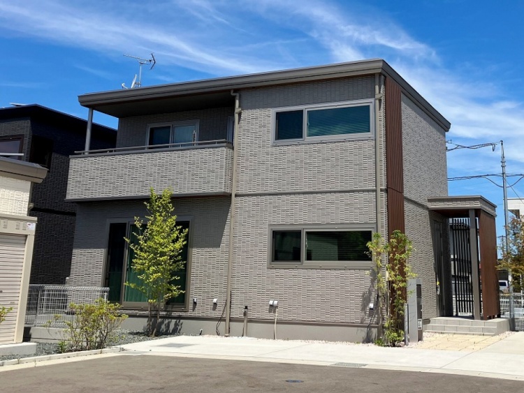 グレーを基調とした2階建て住宅のB棟外観。玄関周りに植栽が植えられています。