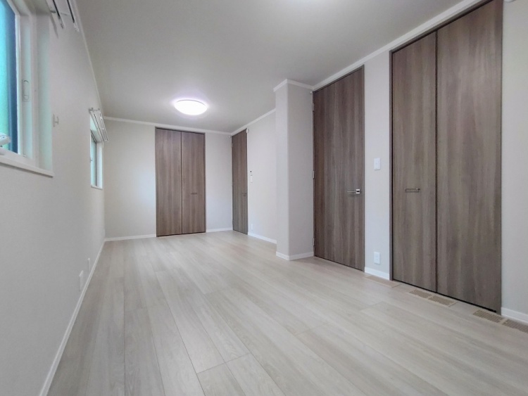 細長い部屋に小さな窓が三つ並び、やわらかな光が差し込んでいる。落ち着いた色合いの床と壁が穏やかな雰囲気を作り出し、シンプルで使いやすい空間が広がっている。