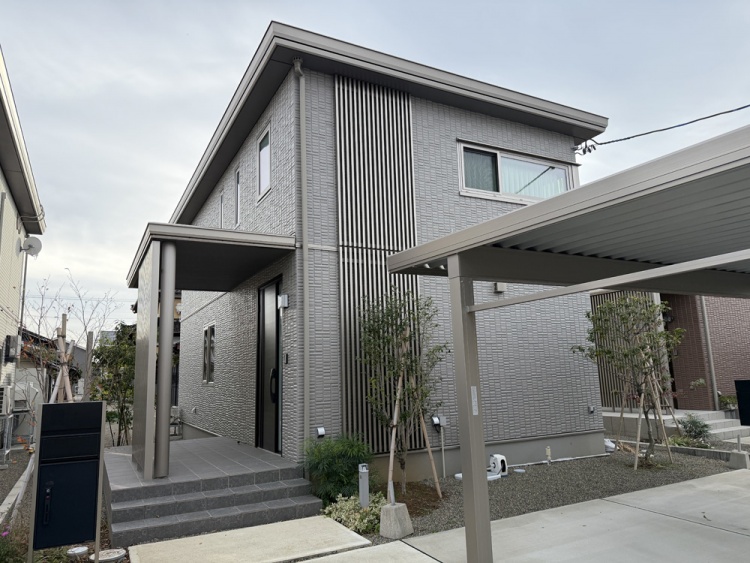 グレーの外壁の２階建て住宅のA棟外観。玄関前にカーポートがあります。