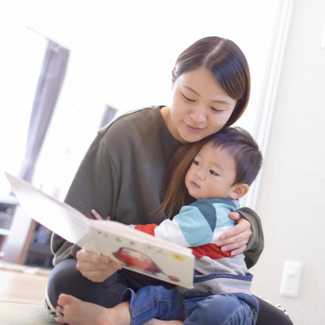 Confidenceイメージ画像。母親が幼い息子を膝に抱きながら、一緒に絵本を読んでいます。息子はリラックスした様子で本に見入っており、母親は優しい表情で寄り添っています。穏やかな親子のひとときが伝わる温かい場面です。