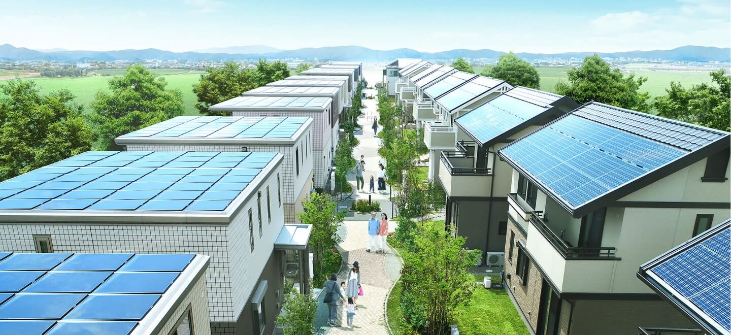 エネルギーをシェアするのイメージ画像。緑豊かな並木道に沿って、太陽光パネルが設置された家々が整然と並んでいる住宅街の風景。歩道には家族連れやカップルが散歩を楽しんでいます。